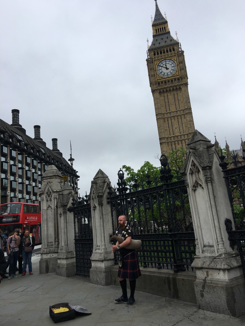 man playing bagpipes in front of big ben