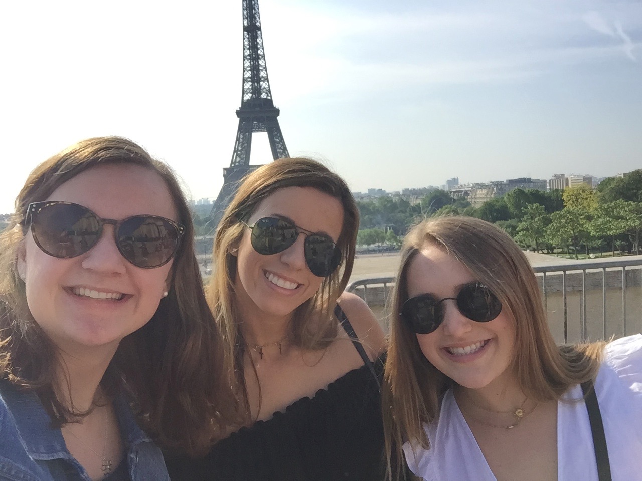 students take a selfie in front of eiffel tower