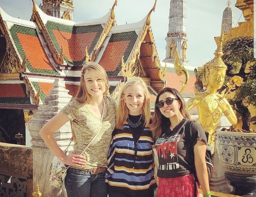 friends in Thailand posing in front of temple