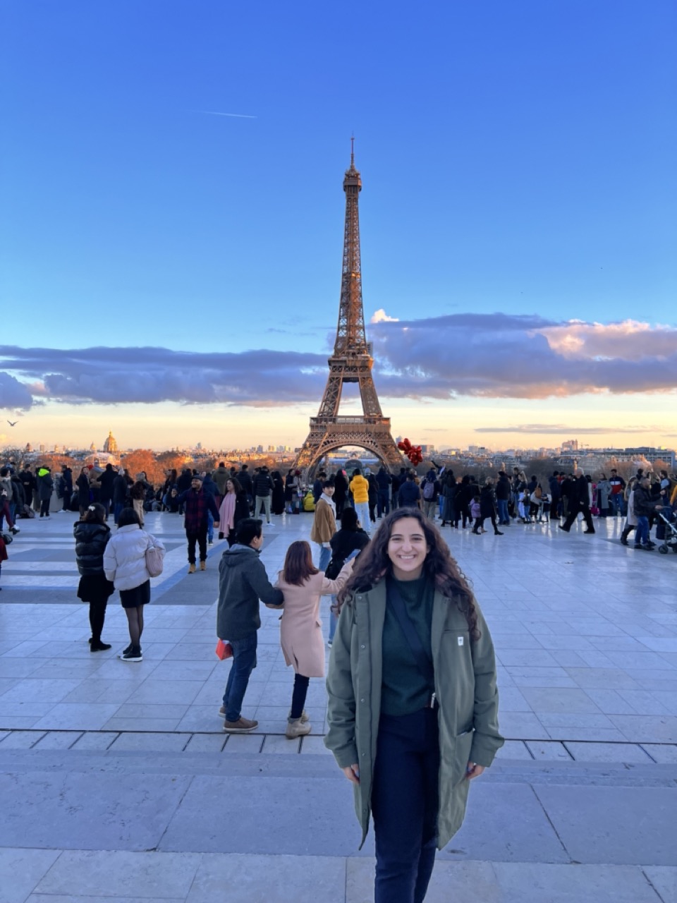 Young woman standing in a plaza with the Eiffel Tower in the distance